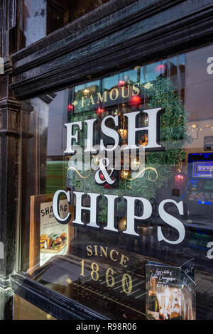 Closeup of Fish and Chip shop sign with Lettering stuck on a Pub window in London Stock Photo