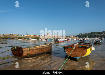 Traditiona wooden rowing skiffs on moorings on an ebb tide St.ives Cornwall UK Europe Stock Photo