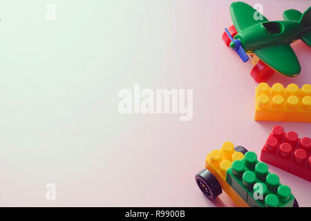 Border of colorful plastic kids toys with building blocks, airplane on white with copy space Stock Photo
