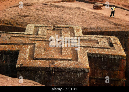 Lalibela, Ethiopia, 13th June 2009: Unidentified man standing outside of the rock-hewn church of Saint George (Bet Giyorgis) Stock Photo