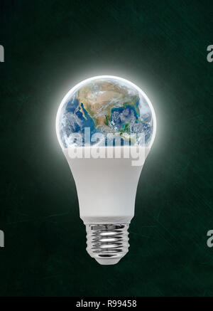 Illuminated energy efficient Light Emitting Diode LED light bulb with planet earth inside. Concept of ecology, environmental conservation; green alter Stock Photo