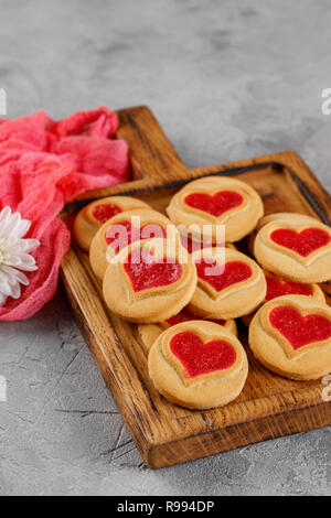 Cookies with a heart-shaped filling in on a wooden board. Close-up. Concept for Valentine's Day. Stock Photo