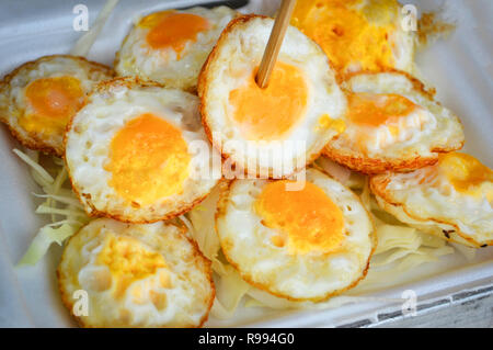 fried egg on rice in box / Quail fried egg with Vegetable in street food Stock Photo