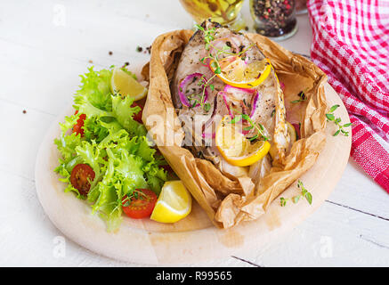 White fish steak (carp) baked in parchment paper with vegetables. Fish dish. Stock Photo