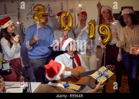 Happy business group people in Santa hat having fun for celebrity Christmas party in office. Stock Photo
