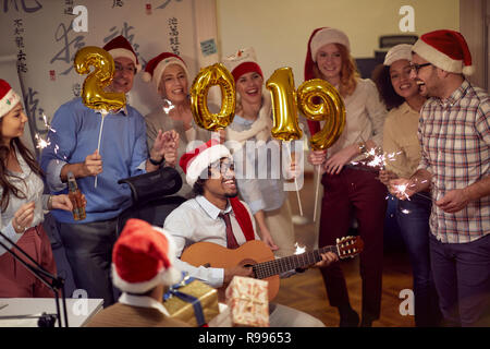 colleagues having fun at new year celebration at work Stock Photo