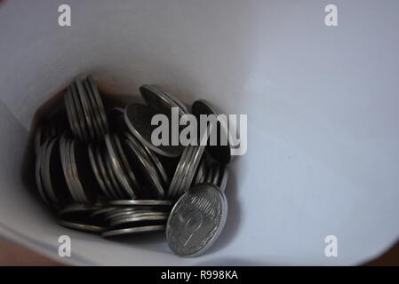 An envelope with money, in a white paper bag are small money, white light metal pennies, cash savings in the banking system, a bank and bank payments. Stock Photo