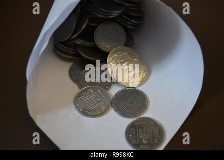 An envelope with money, in a white paper bag are small money, white light metal pennies, cash savings in the banking system, a bank and bank payments. Stock Photo