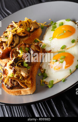 Delicious breakfast of shiitake toasts and fried eggs close-up on a plate. vertical Stock Photo