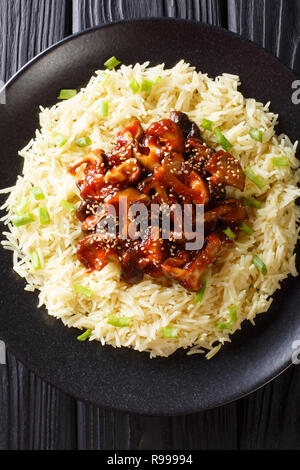 Crisp and delicate sesame shiitake mushrooms with a side dish of rice close-up on a plate on the table. Vertical top view from above Stock Photo