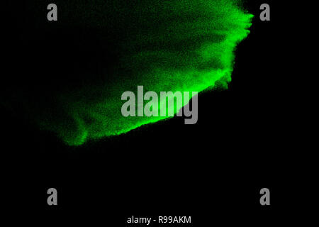 Green sand explosion isolated on black background. Abstract sand cloud. Green sand splash against  on dark background. Sandy fly wave in the air. Stock Photo