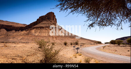 Morocco, Zagora Province, Tazarine, rock outcrop, former volcanic plug beside road, panoramic Stock Photo