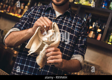 https://l450v.alamy.com/450v/r99nkh/young-barman-standing-at-bar-counter-holding-wine-glass-cleaning-with-tissue-close-up-r99nkh.jpg