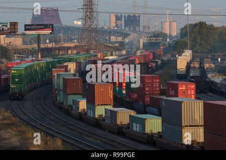 Rail yard with freight containers in Hammond, Indiana with the Chicago Skyway bridge in the distance. Stock Photo