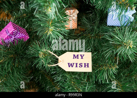 Gift boxes and tag with inscription "MY WISH" on christmas tree Stock Photo