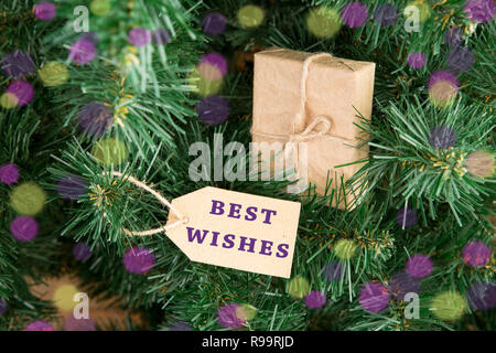 Gift boxes and tag with inscription "BEST WISHES" on christmas tree Stock Photo