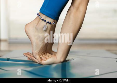 Close up of a yogi resting in a home practice on a blue yoga mat. Yoga home practice concept. Stock Photo