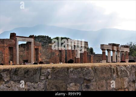 Pompeii, Italy - October 23rd 2018: Tourists survey ruins of the ancient city of Pompeii that was destroyed by the eruption of Mount Vesuvius in 79AD. Stock Photo