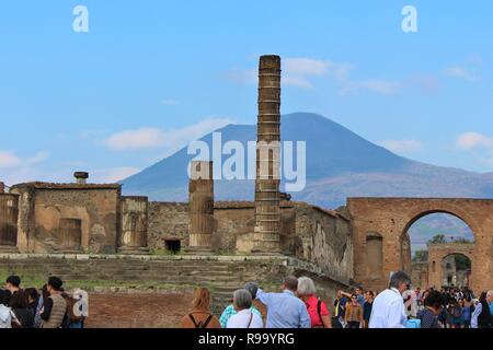 Pompeii, Italy - October 23rd 2018: Tourists explore the ruins of the ancient Roman city of Pompeii, with the Mount Vesuvius volcano in the background Stock Photo