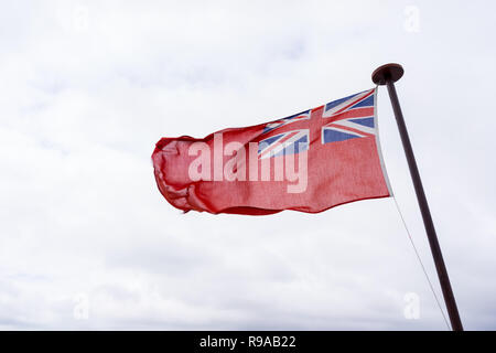 uk red ensign the british maritime flag flown in white cloudy sky Stock Photo