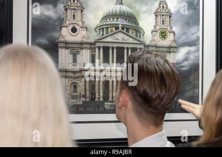 Brentwood, Essex, UK. 21st December 2018.  The opening of the Penny Black contemporary Art Gallery in Brentwood with Jason John 'JJ' Adams  a leading English mixed media contemporary pop artist and graphic designer Visitors admire a piece of JJ Adams work Credit Ian Davidson/Alamy Live News Stock Photo