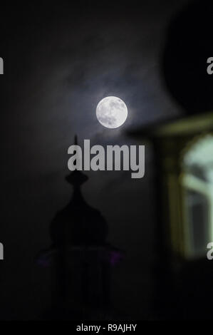 Brighton, Sussex, UK. 21st December 2018. A beautiful full moon over the Royal Pavilion in Brighton this evening as the shortest day of the year comes to an end on the winter solstice Credit: Simon Dack/Alamy Live News Stock Photo