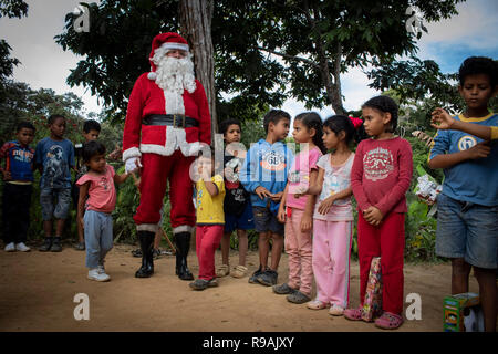 Caracas, Venezuela. 21st Dec, 2018. 'Santa Claus' comes to a congregation in the countryside east of Caracas and brings gifts to children through the initiative 'Un Juguete: Una Buena Noticia' (A Toy, a Good News). The initiative was founded by reporters and journalists in Venezuela. The group also provides school supplies for children from a poorer neighbourhood in Caracas. Credit: Rayner Pena/dpa/Alamy Live News Stock Photo