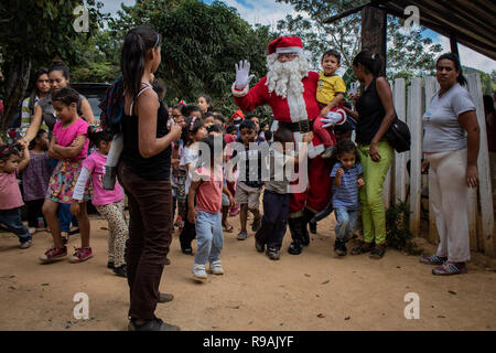Caracas, Venezuela. 21st Dec, 2018. 'Santa Claus' comes to a congregation in the countryside east of Caracas and brings gifts to children through the initiative 'Un Juguete: Una Buena Noticia' (A Toy, a Good News). The initiative was founded by journalists in Venezuela. The group also provides school supplies for children from a poorer neighbourhood in Caracas. Credit: Rayner Pena/dpa/Alamy Live News Stock Photo