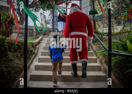 Caracas, Venezuela. 21st Dec, 2018. 'Santa Claus' comes to a congregation in the countryside east of Caracas and brings gifts to children through the initiative 'Un Juguete: Una Buena Noticia' (A Toy, a Good News). The initiative was founded by reporters and journalists in Venezuela. The group also provides school supplies for children from a poorer neighbourhood in Caracas. Credit: Rayner Pena/dpa/Alamy Live News Stock Photo