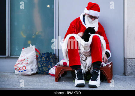 London, UK. 21st Dec, 2018. A homeless man dressed as Father Christmas is seen seated on London's Oxford Street.On 18 December, Gyula Remes from Hungary died after choking on his own vomit outside the Houses of Parliament. According to official statistics published by the Office for National Statistics, 597 homeless people died in England and Wales in 2017. Credit: Dinendra Haria/SOPA Images/ZUMA Wire/Alamy Live News Stock Photo