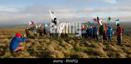 Lockerbie, Scotland, UK. 22nd December, 2018. A Walk for Peace up Burnswark near Lockerbie in memory of those who died in the Lockerbie Disaster. Krystal Anderson on Rebel with the Lockerbie Standard. The walk follows the age-old tradition in Scotland of taking to the hills to find peace and contemplate the future. The walk up Burnswark with the flags of the 21 nations that the victims from the Pan Am flight 103 came from was organises by representatives from Allanton World Peace Sanctuary and local artists Credit: Allan Devlin/Alamy Live News Stock Photo