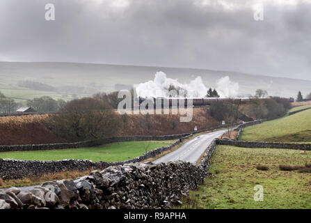 Horton-in-Ribblesdale, North Yorkshire, UK. 22nd December, 2018. Through squally rain The Flying Scotsman steam locomotive hauls the 'Christmas Dalesman' on a round trip from Manchester. Travelling on the famous Settle-Carlisle railway line, the train is seen here at Horton-in-Ribblesdale in the Yorkshire Dales National Park, on its way to Carlisle. Credit: John Bentley/Alamy Live News Stock Photo