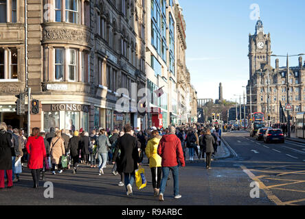Edinburgh, Scotland, UK. 22nd December 2018, Super Saturday on Princes Street in the Scottish capital, thousands of people hit the pavements and streets but not a lot of shopping bags visible for this final weekend before Christmas. Although retailers have launched an unprecedented amount of pre-Christmas  sales in a final bid for shoppers money. Some of the younger generation opted for the ice rink in St Andrew's Square rather than the shopping streets. Stock Photo