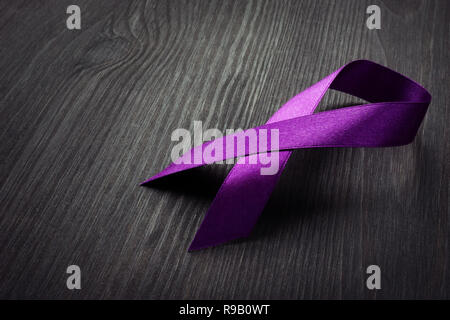 Purple awareness ribbon on a desk. Pancreatic cancer. Stock Photo