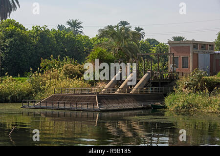 View across river Nile in Egypt through rural landscape with large irrigation water pumping station Stock Photo