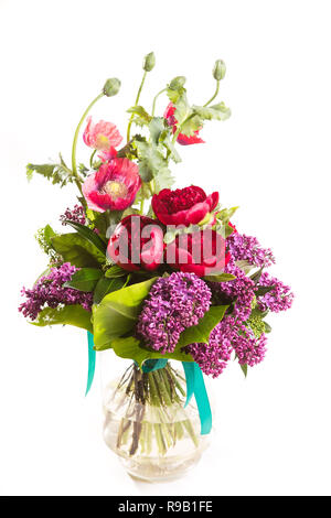 Large beautiful lush bouquet of flowers bright multicolored poppy, peony and lilac in a transparent vase on a white isolate background. Stock Photo