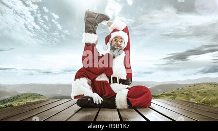 Santa Claus in traditional red white costume in front of white snow winter landscape panorama. Christmas, x-mas, gifts concept. Stock Photo