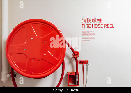 An fire hose hanging on the wall Stock Photo
