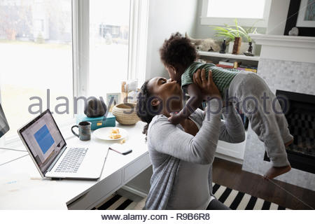 Affectionate mother kissing toddler son