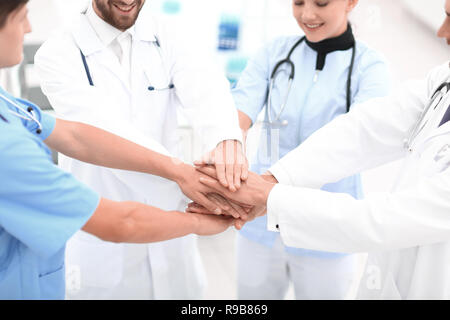 doctors holding hands together at hospital Stock Photo