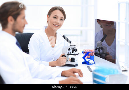 Lab expert working on a test using microscope Stock Photo
