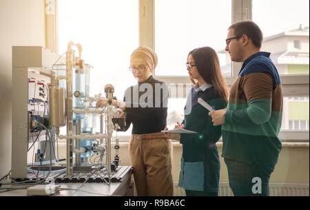 Group of students doing technical vocational practice with young female muslim teacher in the electronic classroom, Education and technology concept Stock Photo
