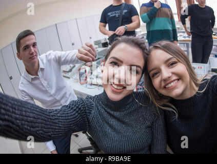group of young happy students doing selfie picture using a smart phone after a successful day in the electronics classroom Stock Photo