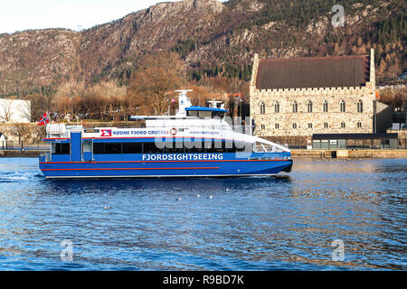 High speed passenger catamaran Rygertroll arriving in the port of Bergen, Norway. Passing the ancient Haakon's Hall. Stock Photo