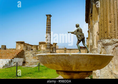 Pompeii ruins: Temple of Apollo with bronze Apollo statue. Remains of ancient Pompeii town destroyed by eruption of volcano Vesuvius, Italy Stock Photo