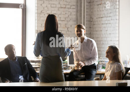 Rear view at female leader speaking at diverse group meeting Stock Photo