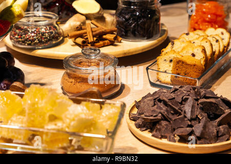 Closeup bakery and snacks, dried fruits, pieces parmesan cheese, honeycombs, dark chocolate, cinnamon sticks, raisin biscotti. Concept degustation pre Stock Photo