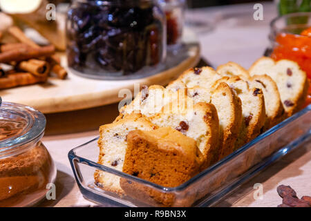 Closeup bakery and snacks, dried fruits and nuts in glass bowls, cinnamon, plate with raisin biscotti. Concept degustation luxury banquet at the prese Stock Photo