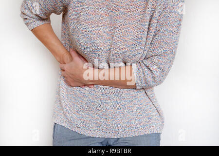 A woman suffering from abdominal pain. Health problem. Woman holding hands on her stomach Stock Photo