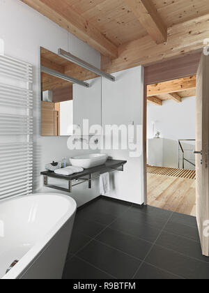 interiors shots of a modern bathroom with wooden ceiling in the foreground the bathtub and the counter top washbasin Stock Photo